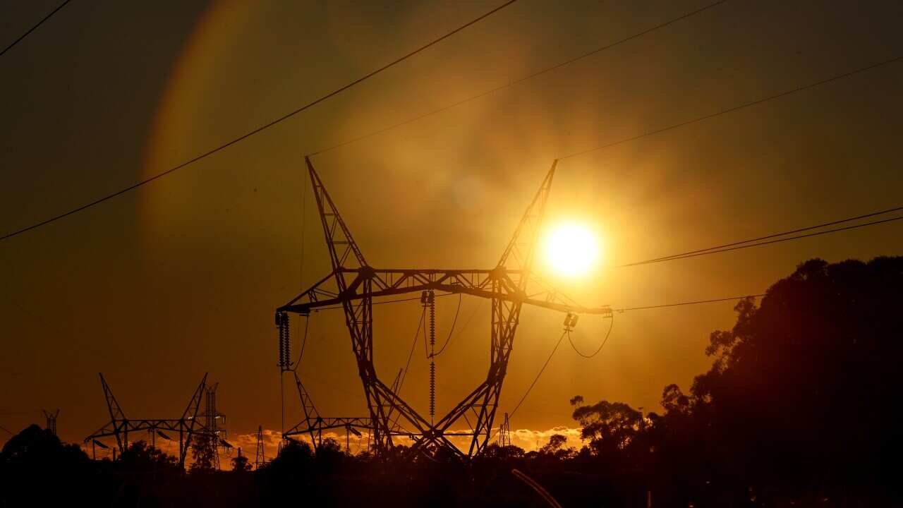 Electricity transmission lines with the sun shining brightly behind