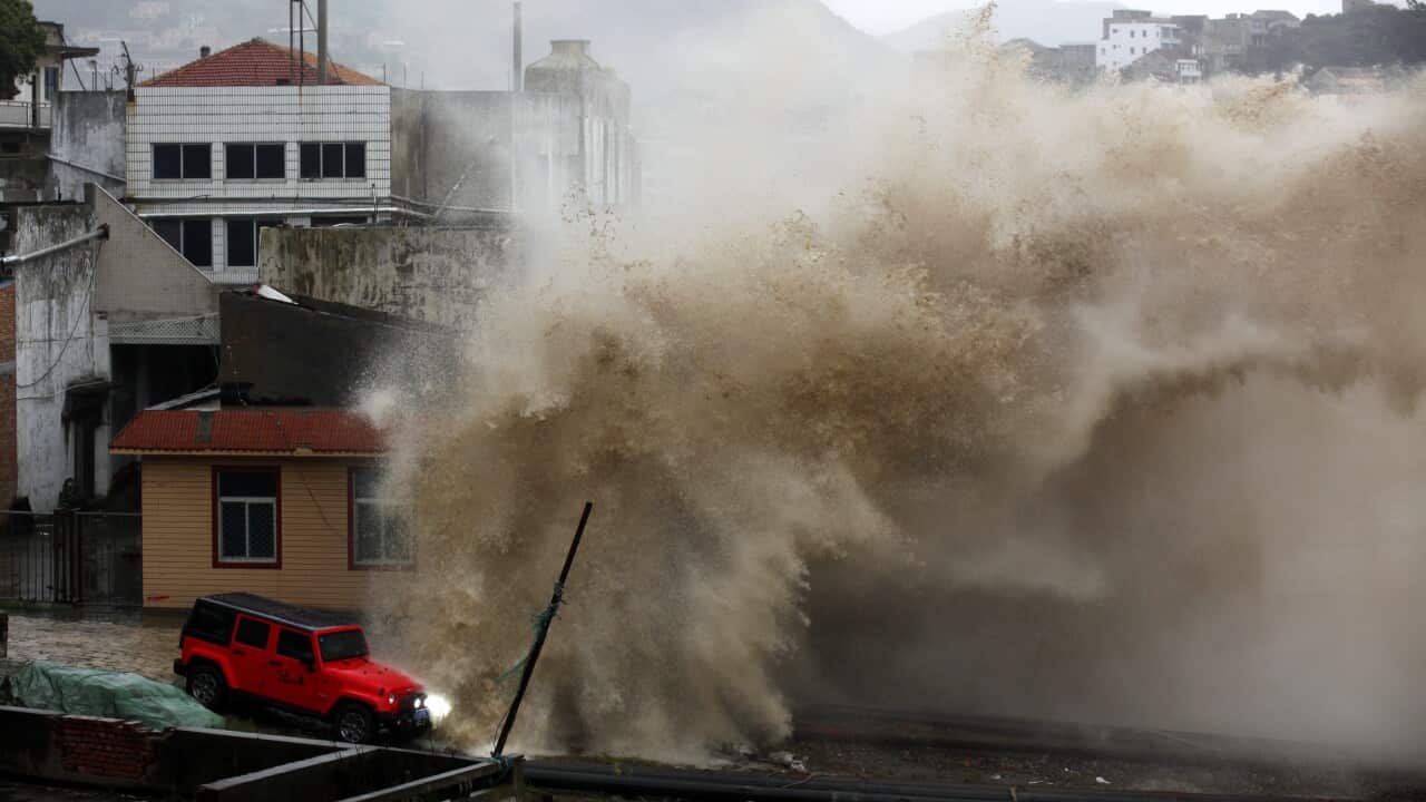 A strong wave breaks over a vehicle along the shore ahead of the landfall of Typhoon Chan-Hom in Wenling in eastern China's Zhejiang province.  