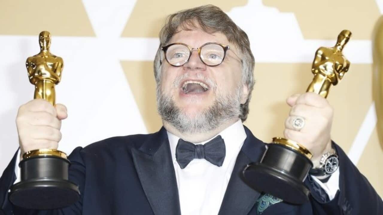 Guillermo del Toro holding the Oscars for Best Picture and Best Director at the 90th Academy Awards