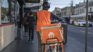A food delivery courier with a Menulog branded bag in the Newtown area of Sydney
