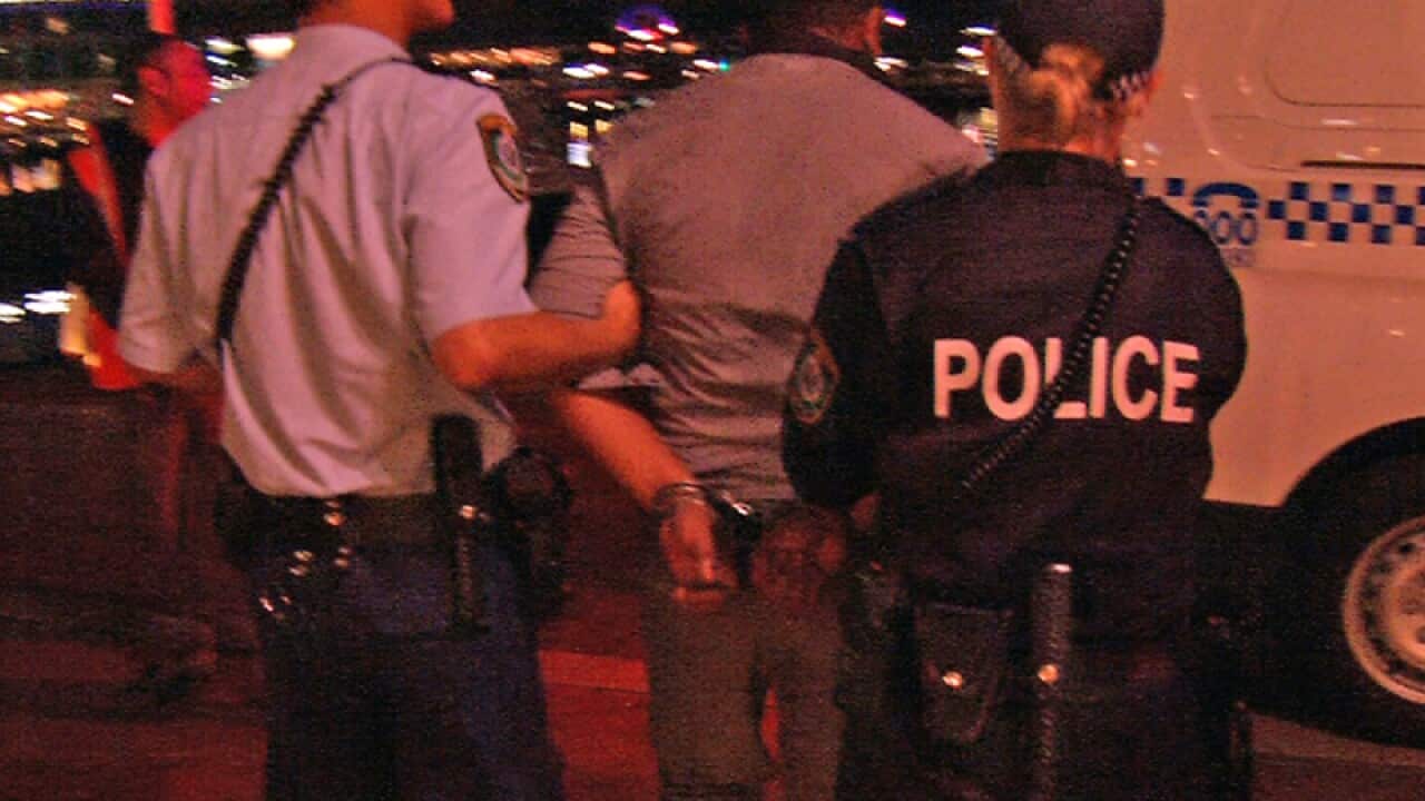 a man being arrested by police following a fatal fight at Cockle Bay
