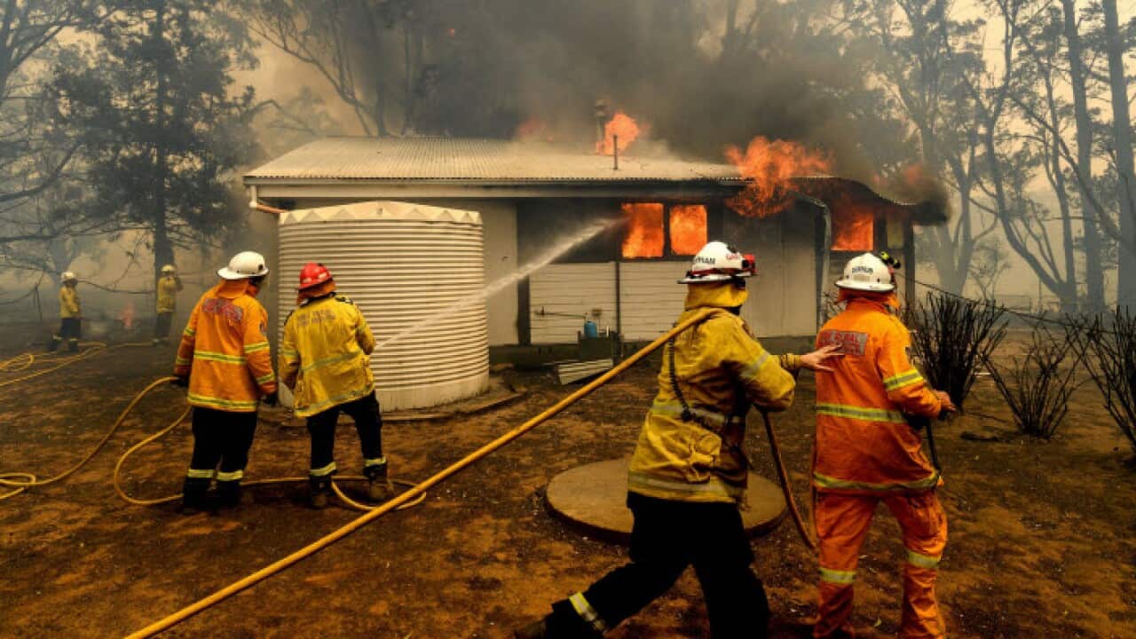Firefighters battle the Morton Fire as it burns a home near Bundanoon, New South Wales, Australia, on Thursday, Jan. 23, 2020. 
