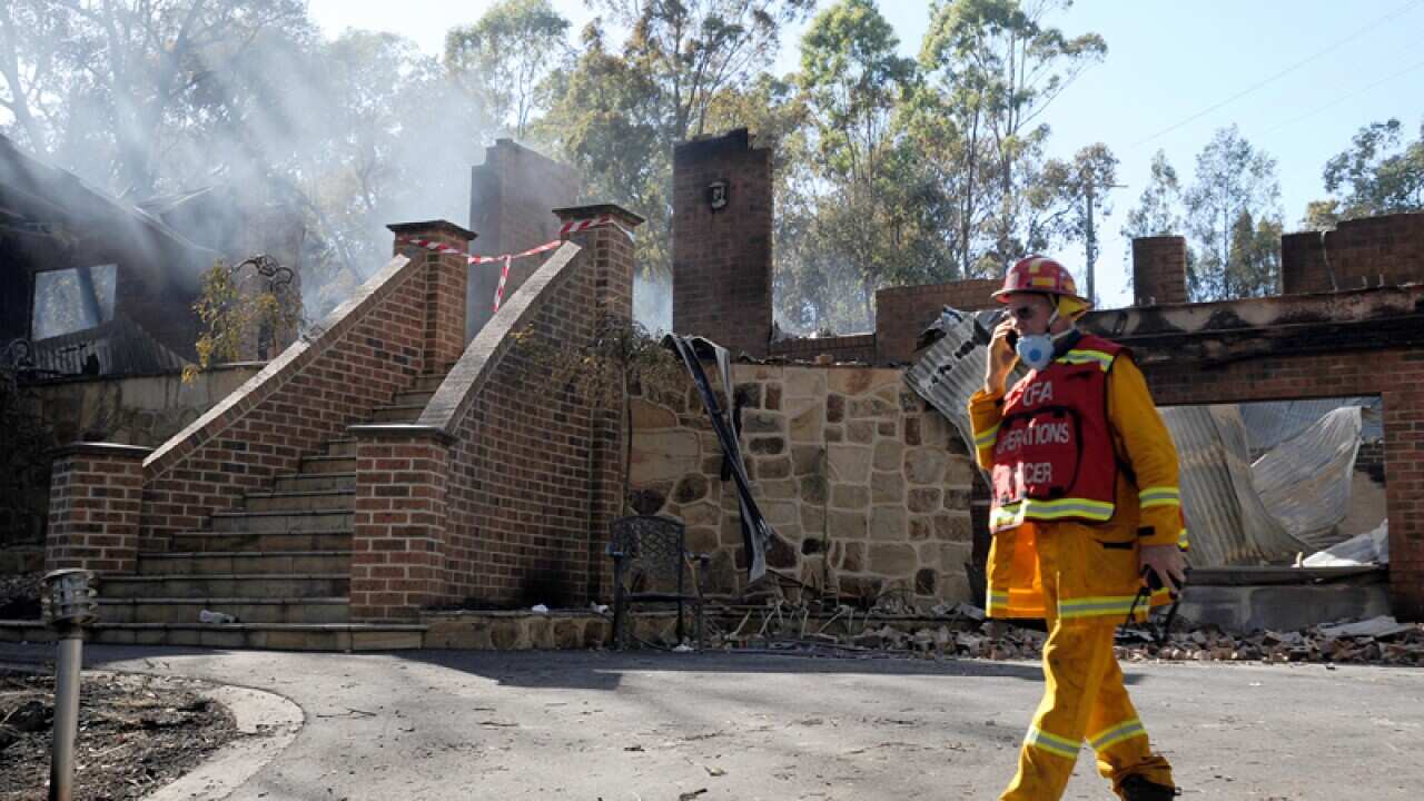 A firefighter attends the scene of a home destroyed by bushfires