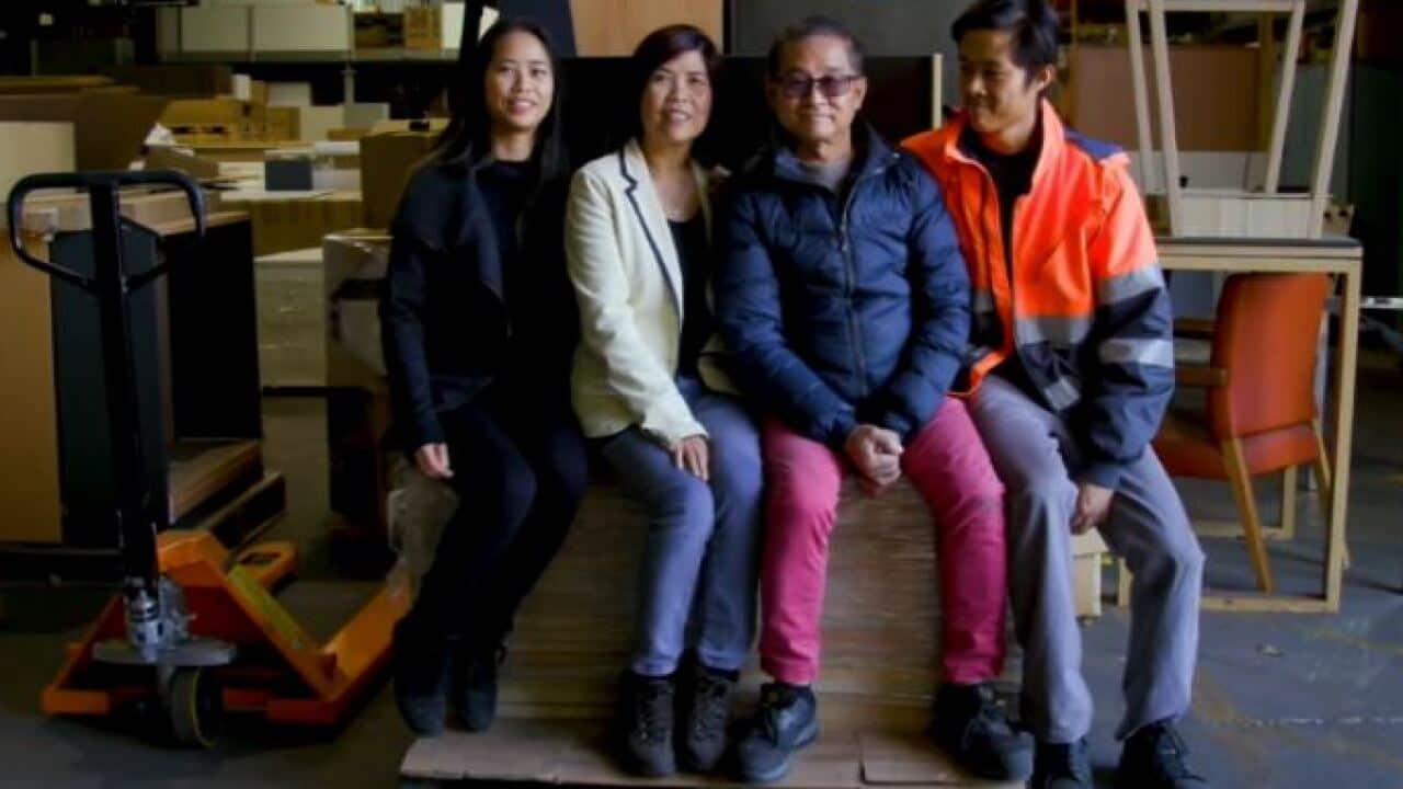 Bill Ngo with his family posing for a photo at his furniture factory.