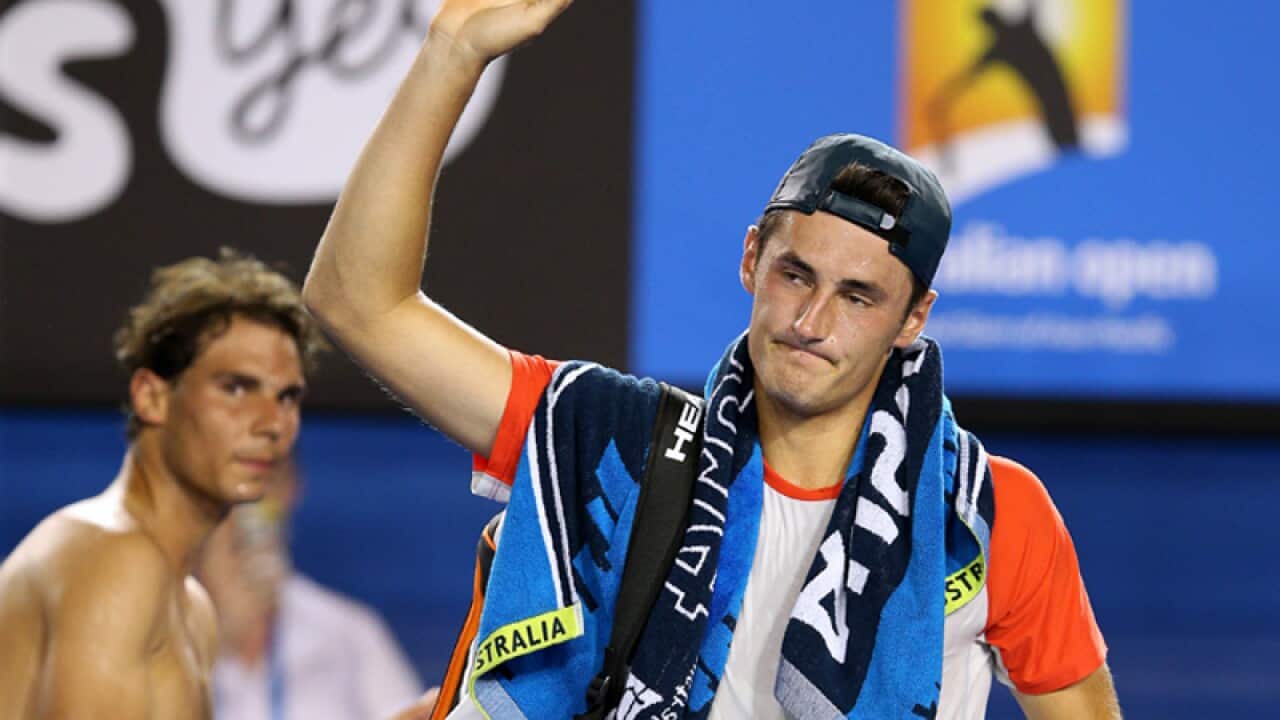 Bernard Tomic (R) leaves Rod Laver Arena with an injury