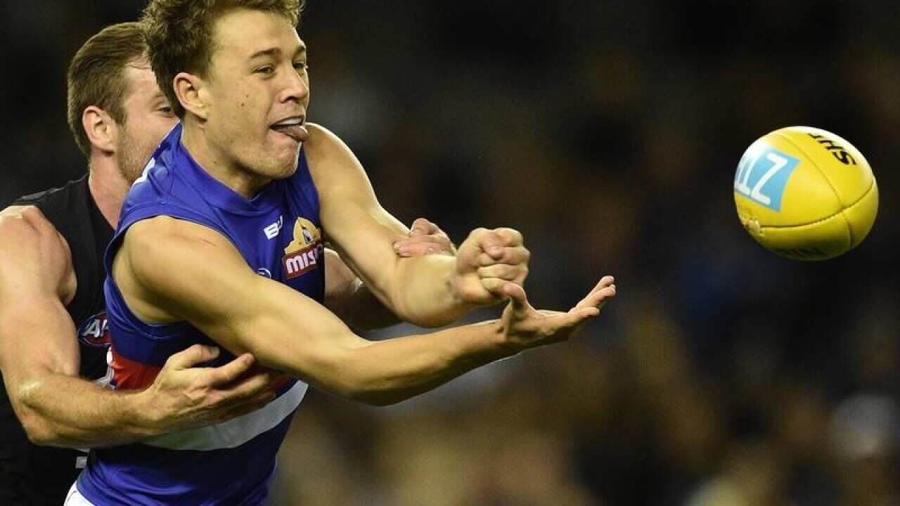 Jack Macrae of the Bulldogs handballs.