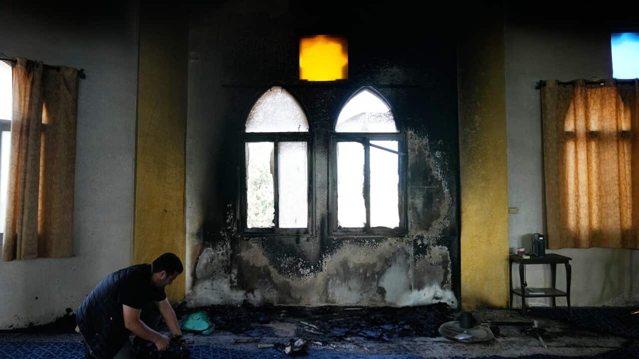 A burnt indoor section of a mosque that was torched and defaced by Israeli settlers overnight (AAP)