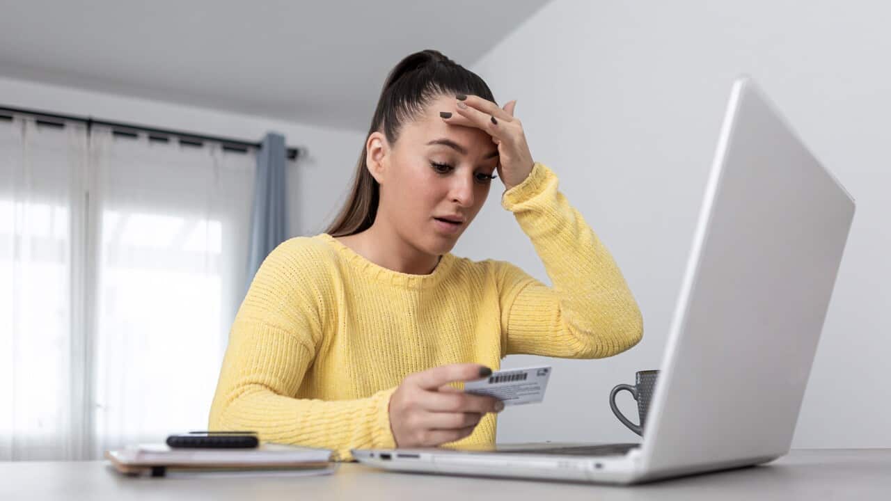 Anxious woman with credit card shopping online