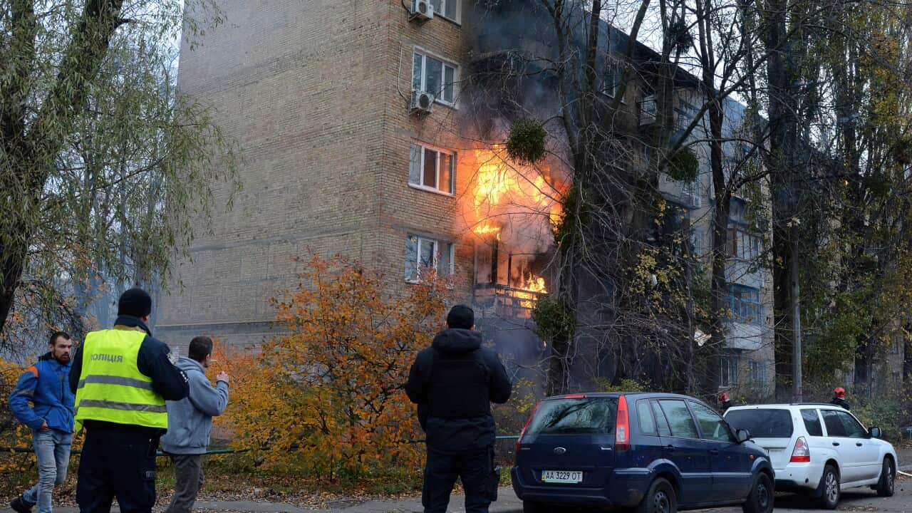 Residents watch a Kyiv apartment building in flames