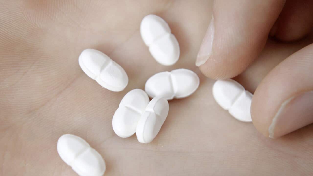 A close-up of pills in the palm of a person's hand