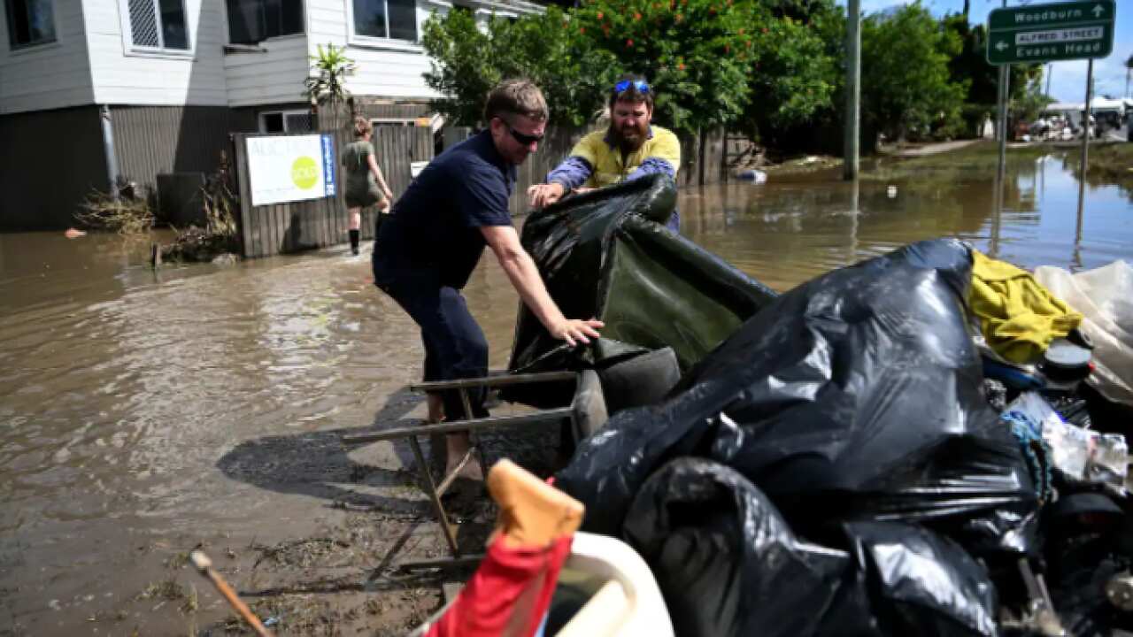Residents remove damaged items from a flood-affected house on March 7, 2022 in Woodburn, NSW.
