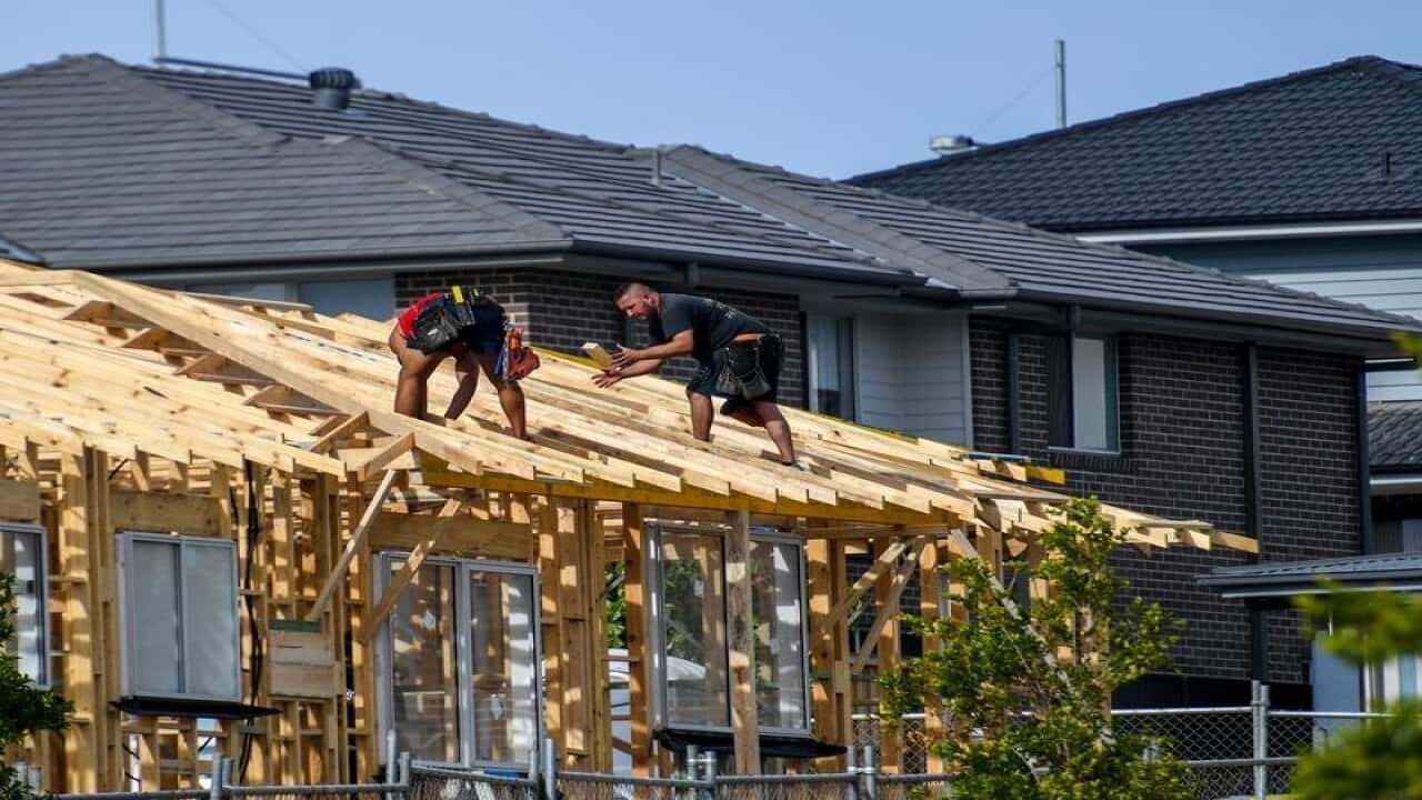 Construction workers build a house in Sydney's southwest