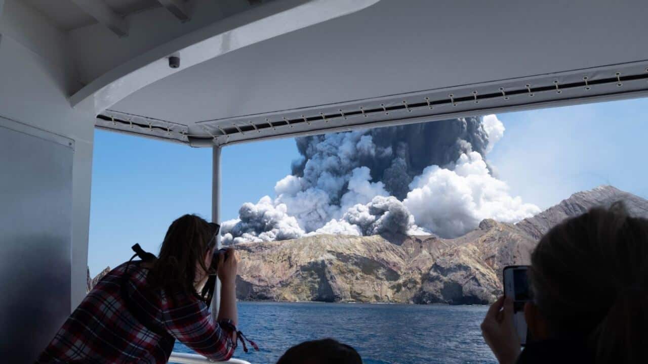Tourists react onbaord a tender boat as the volcano erupts.
