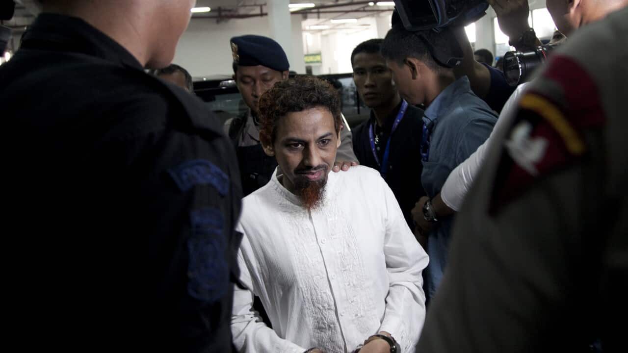 Umar Patek surrounded by security as he makes his way to his sentencing in Jakarta in 2012.