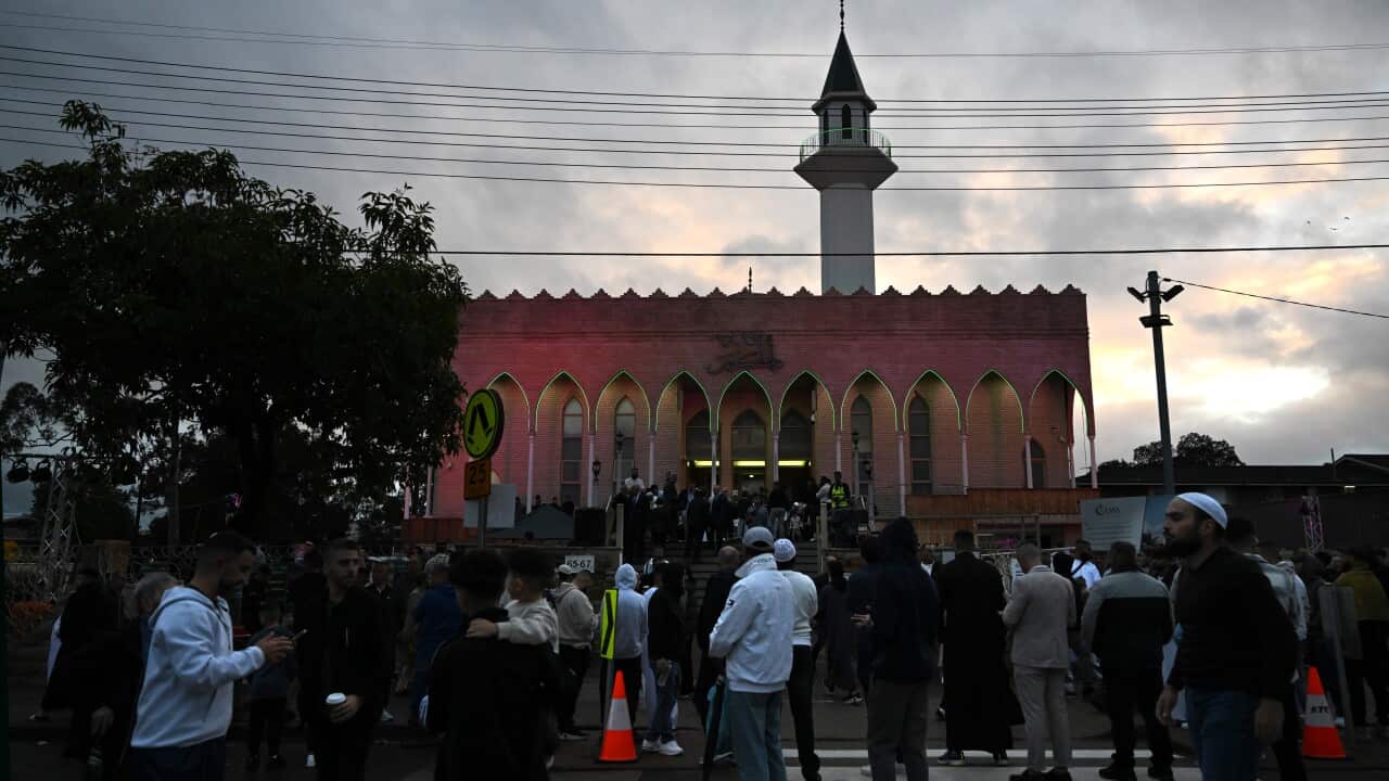 A group of people outside a mosque.