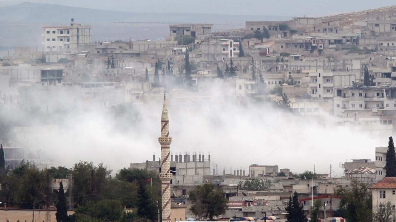 Smoke rises during a clash between Syrian Kurdish fighters and IS.