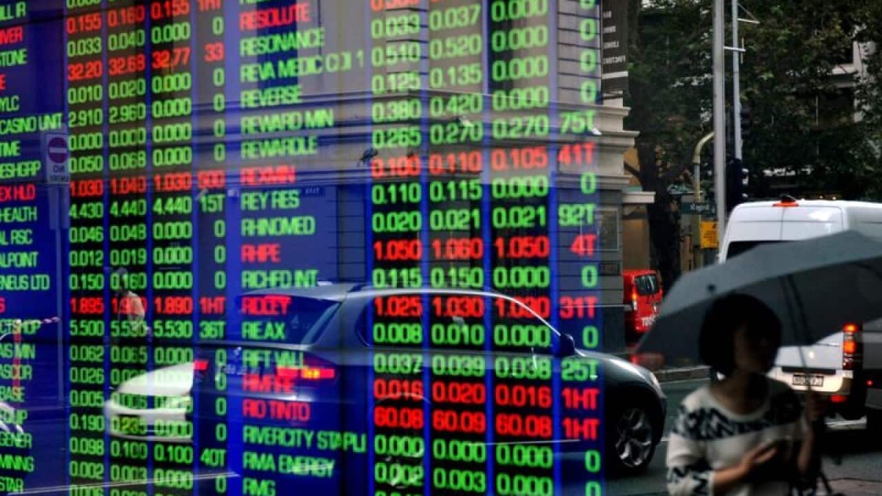 Pedestrians reflected in a window at the ASX.