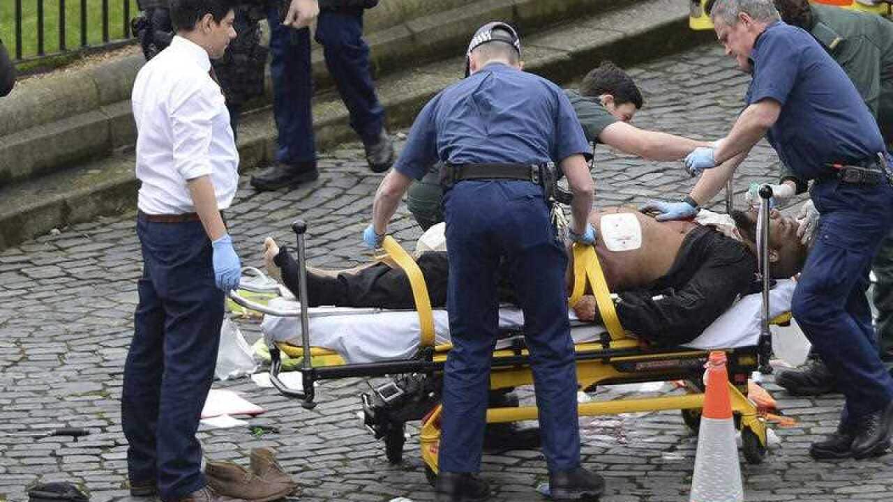 The attacker Khalid Masood is treated by emergency services outside the Houses of Parliament London. British Police named on Thursday March 23, 2017