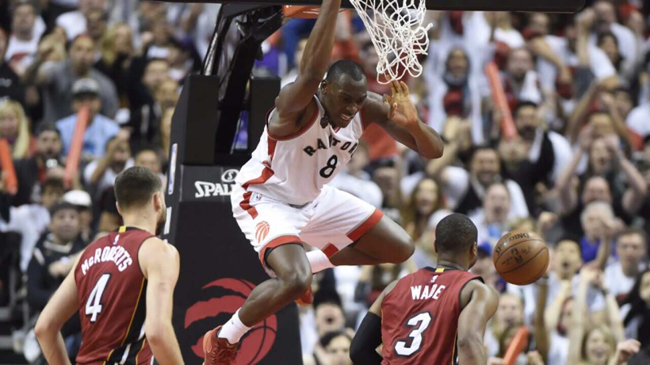 Toronto Raptors' Bismack Biyombo (C) dunks the ball