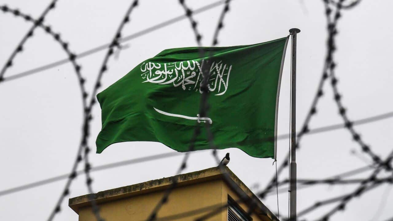 The Saudi Arabian flag is seen behind barbed wire as it flies on the roof at the Saudi Arabian consulate in Istanbul on October 14, 2018. 