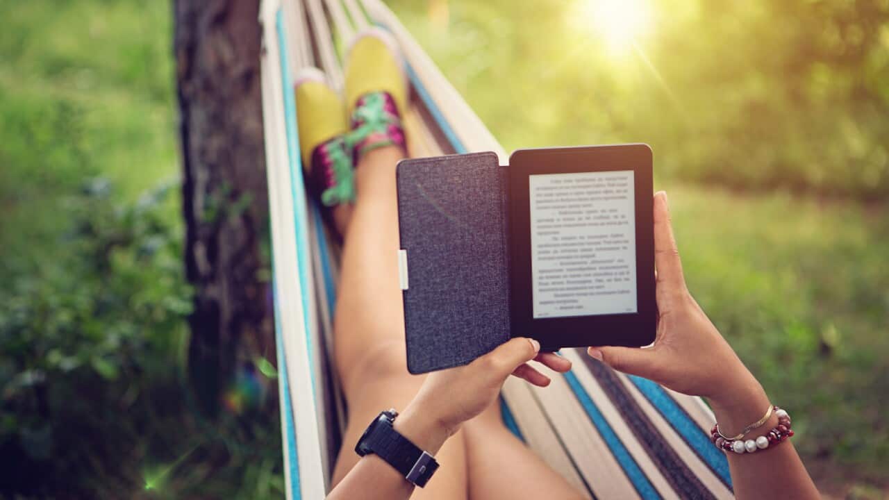 Young person reading e-book in the hammock