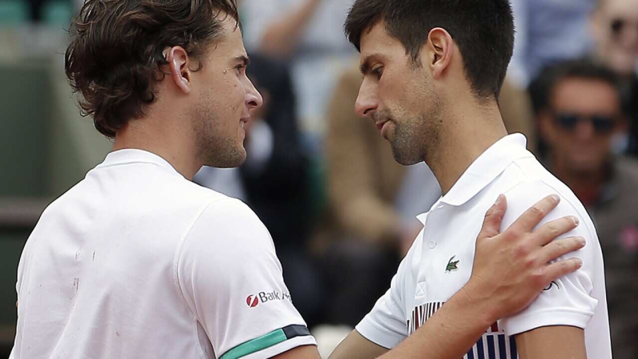Dominic Thiem of Austria (L) reacts with Novak Djokovic of Serbia