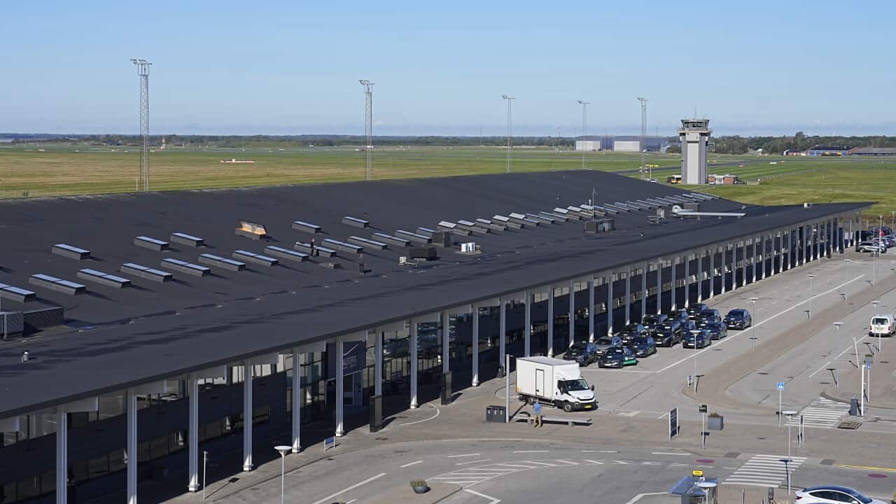A large airport buiding besides a road