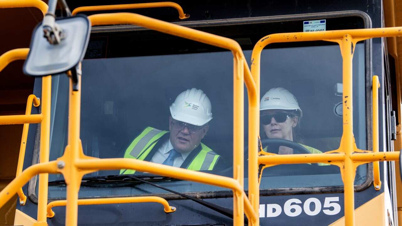 Australian Prime Minister Scott Morrison (left) and truck driver Julie Moore are seen inside a haul truck during a visit to the Western Sydney Airport site in Luddenham, NSW, Monday, March 28, 2022. (AAP Image/Bianca De Marchi) NO ARCHIVING