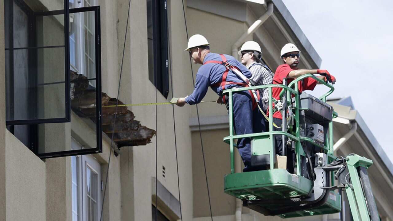 Workers at the scene of a balcony collapse