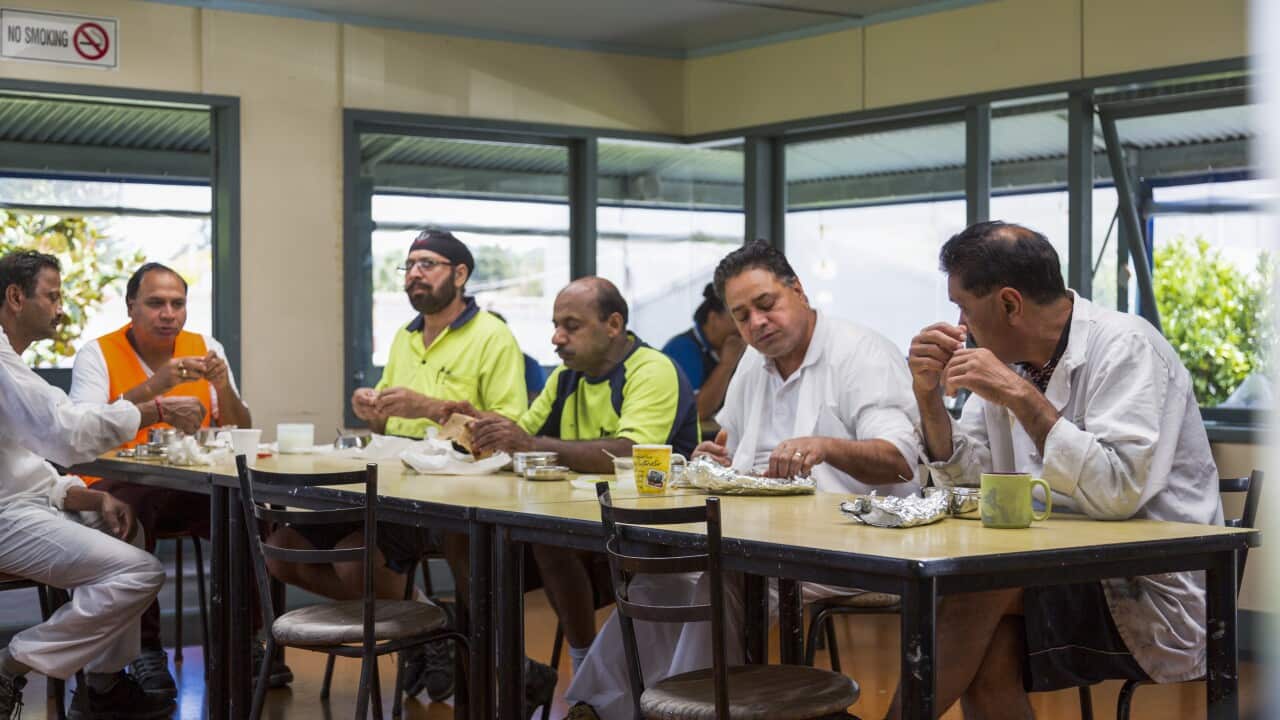 Manual workers on lunch break in factory cafeteria