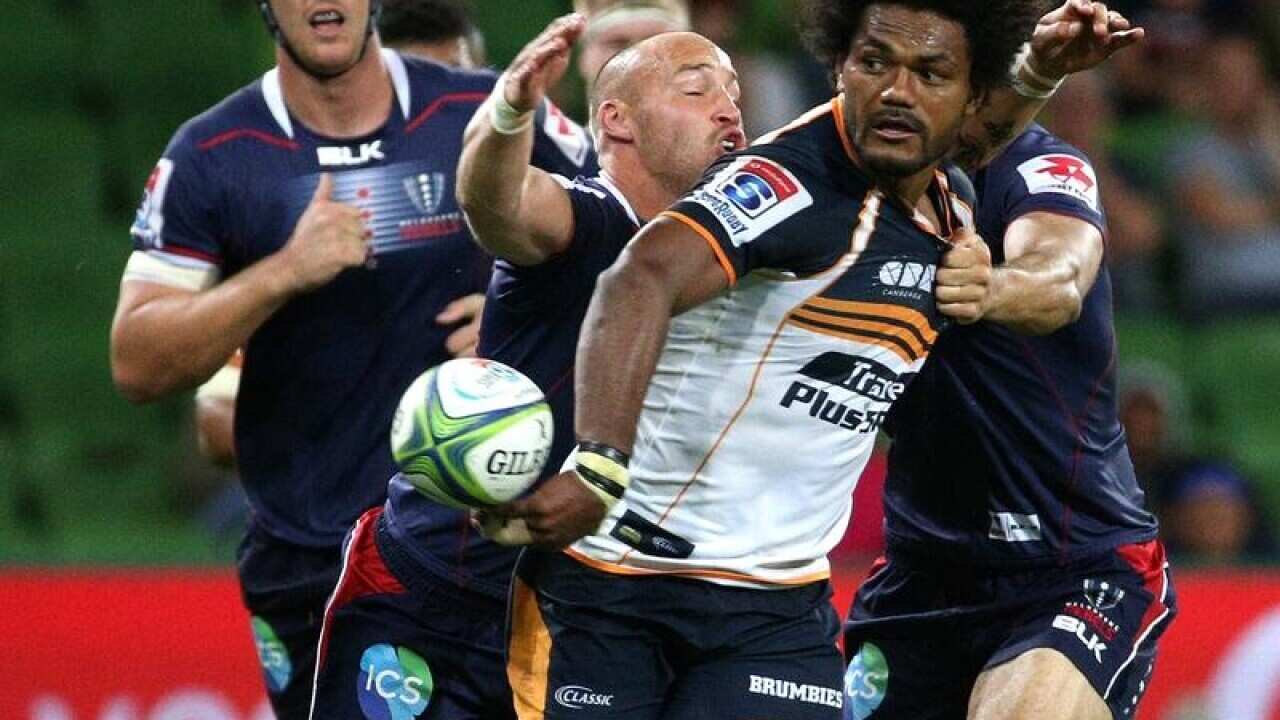 Henry Speight of the Brumbies passes the ball during a rugby match.