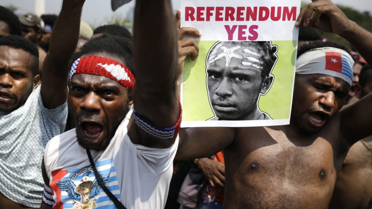 A Papuan activist displays a banner demanding referendum during a rally near the presidential palace in Jakarta, Indonesia.