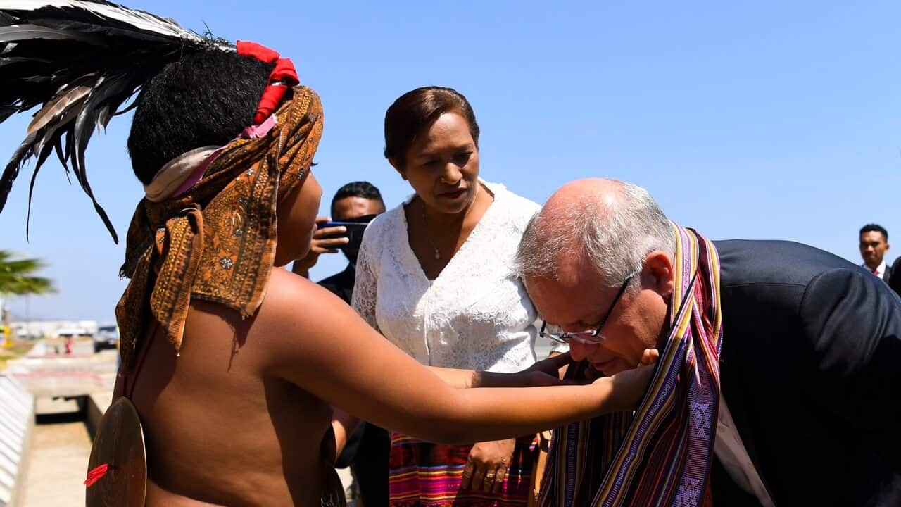 Australian Prime Minister Scott Morrison receives a traditional scarf as he arrives in Dili, East Timor on Friday.