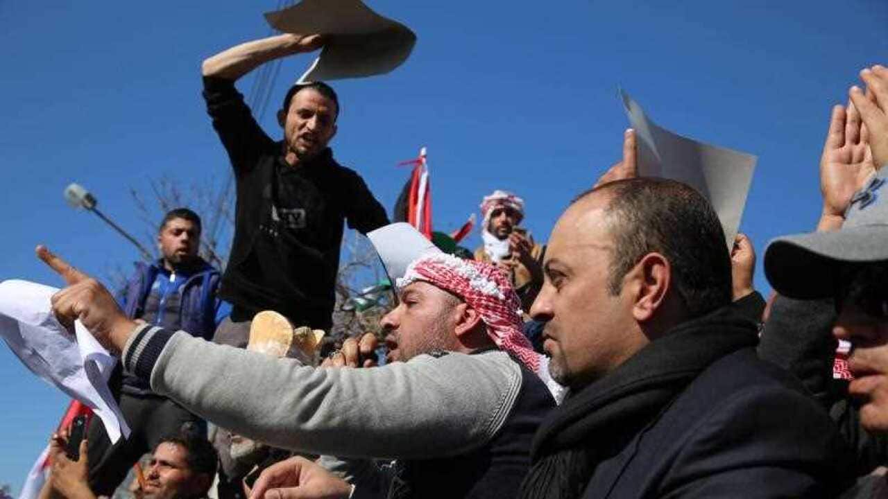 Jordanians shout slogans during a protest against the government move to hike taxes and lifting bread subsidies, in front of the Jordanian Parliament, Amman,