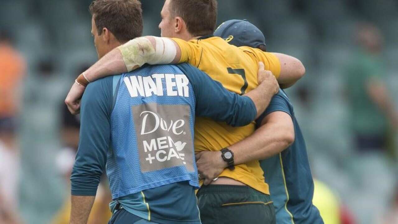 Jack Dempsey of the Wallabies is helped from the field.