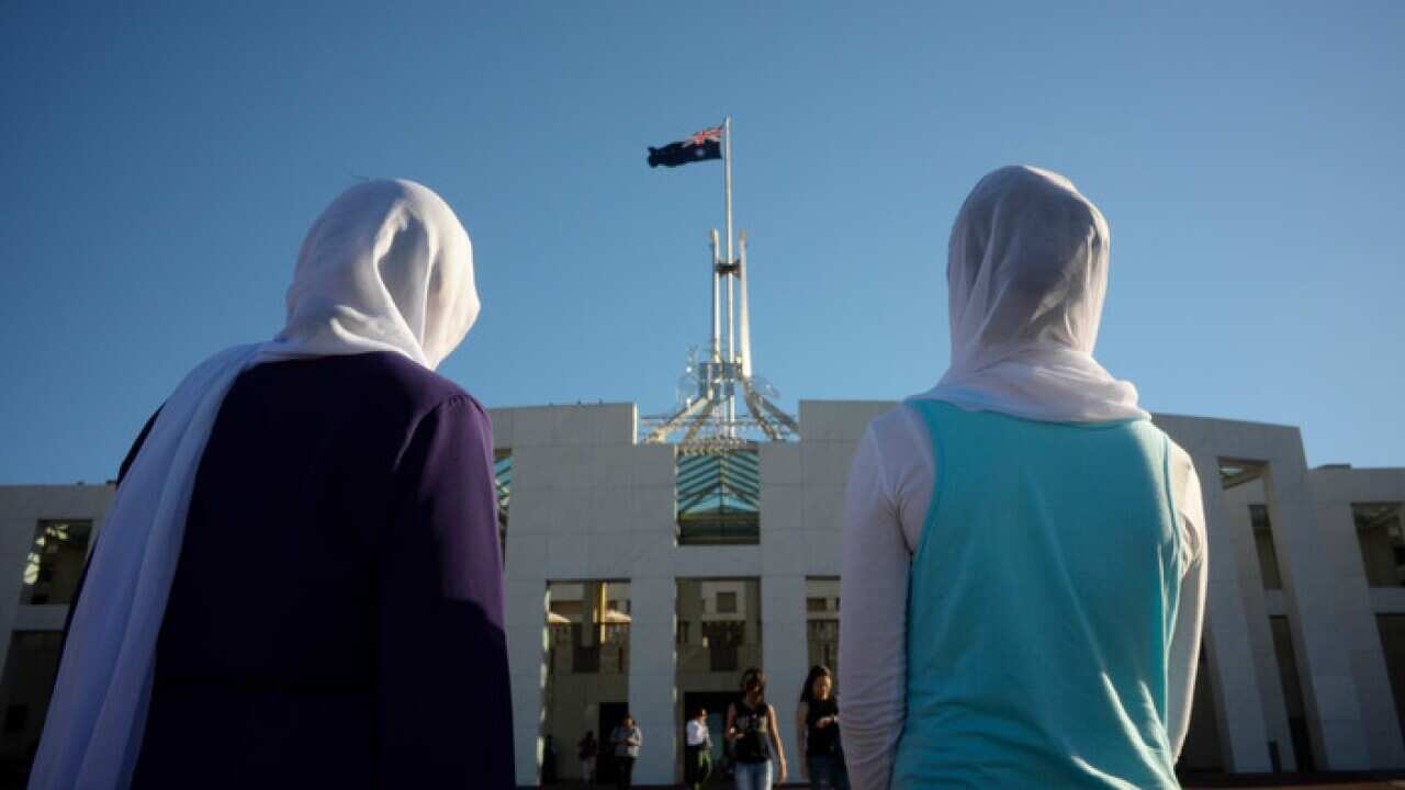 Visitors of Afghan nationality wearing hijabs are seen outside Parliament House in Canberra, Thursday, Oct. 02, 2014.