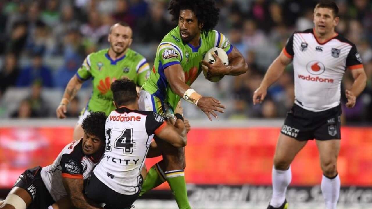 Sia Soliola of the Raiders (centre) is tackled by Nathaniel Roache.