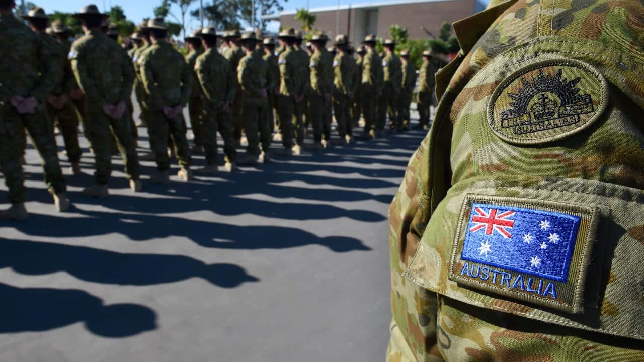 Australian Defence Force personnel standing outside.