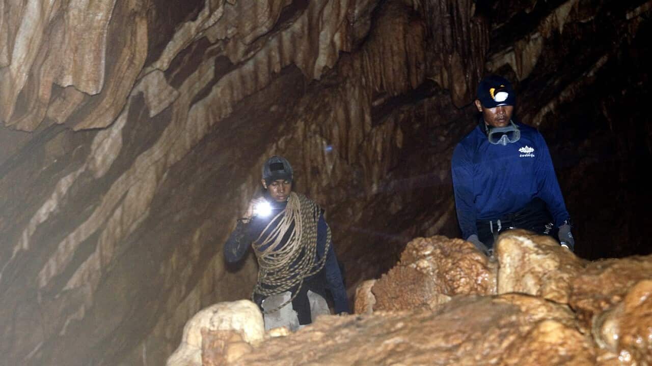 Royal Thai Navy make their way through a cave during rescue operation for missing football players and their coach.