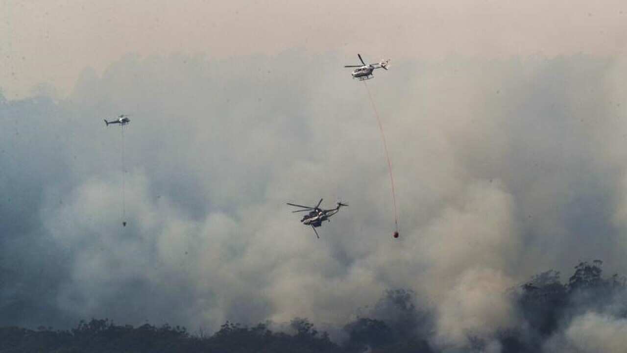 Helicopters drop water on a bushfire in Gippsland, Victoria.