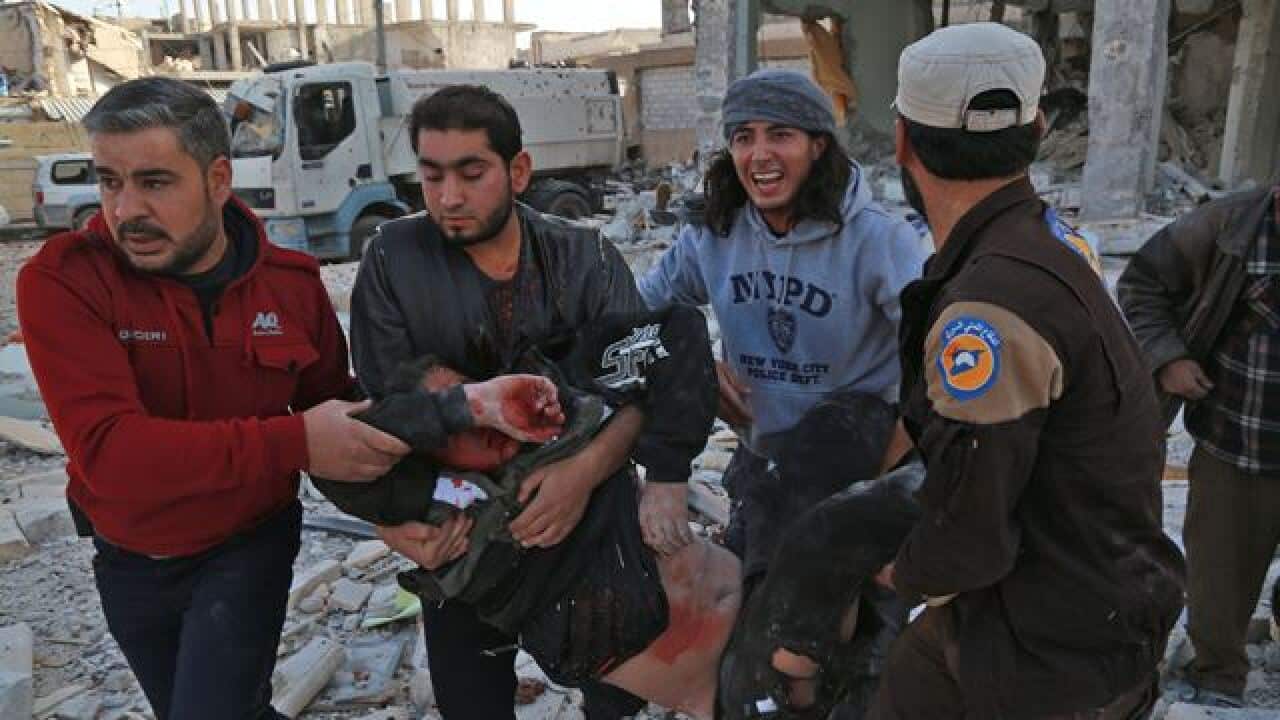 Syrian men carry a wounded man
