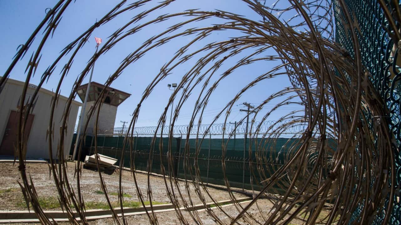 In this photo reviewed by U.S. military officials, the control tower is seen through the razor wire inside the Camp VI detention facility