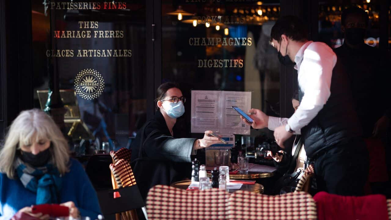 A waiter checks the health pass of costumers with his smartphone in a restaurant in Paris, France, on 28 December, 2021.
