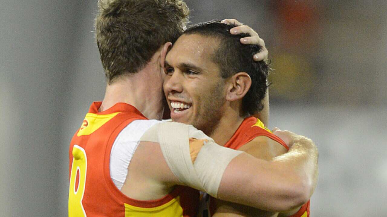 Suns player Harley Bennell (right) celebrates following a goal.