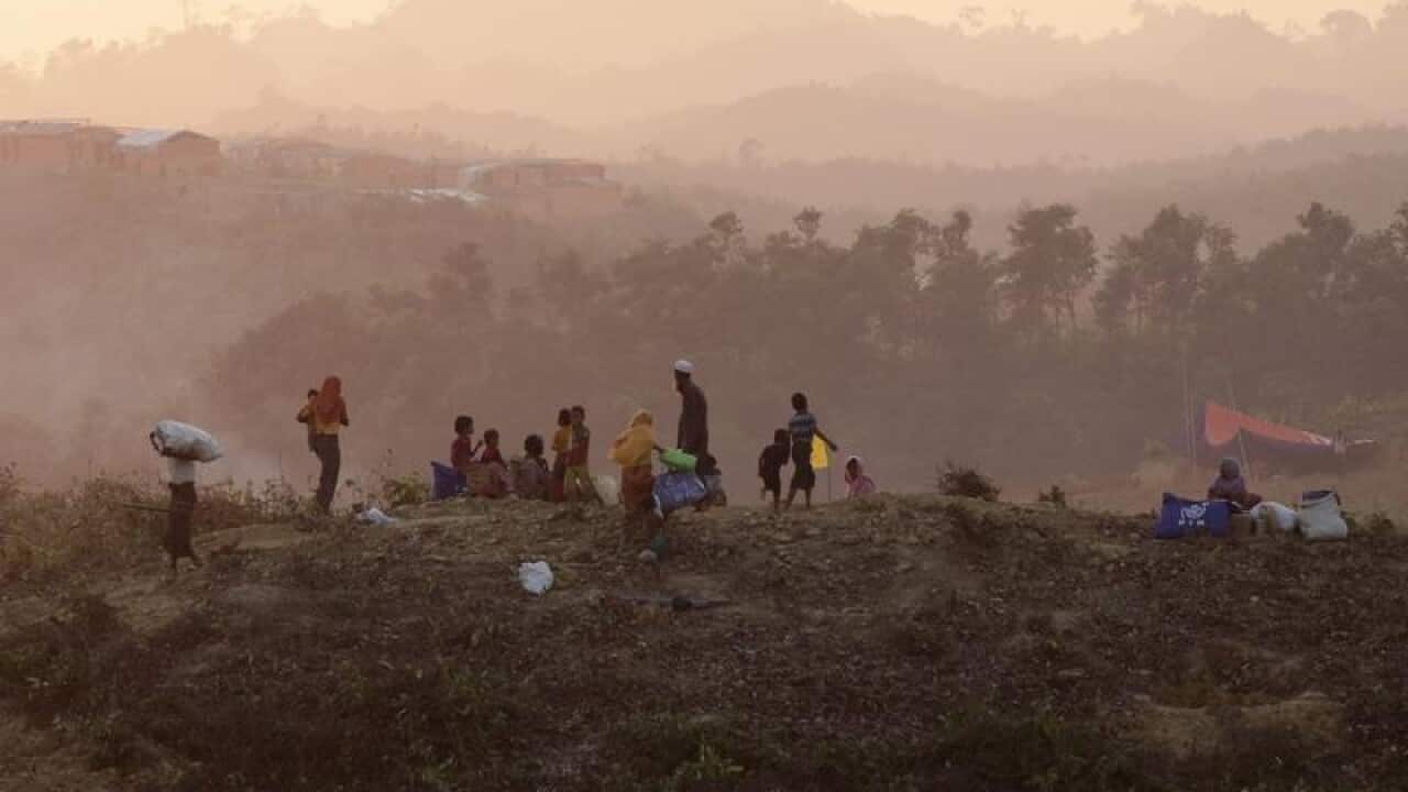 Rohingya refugees wait at a Bangladesh refugee camp.