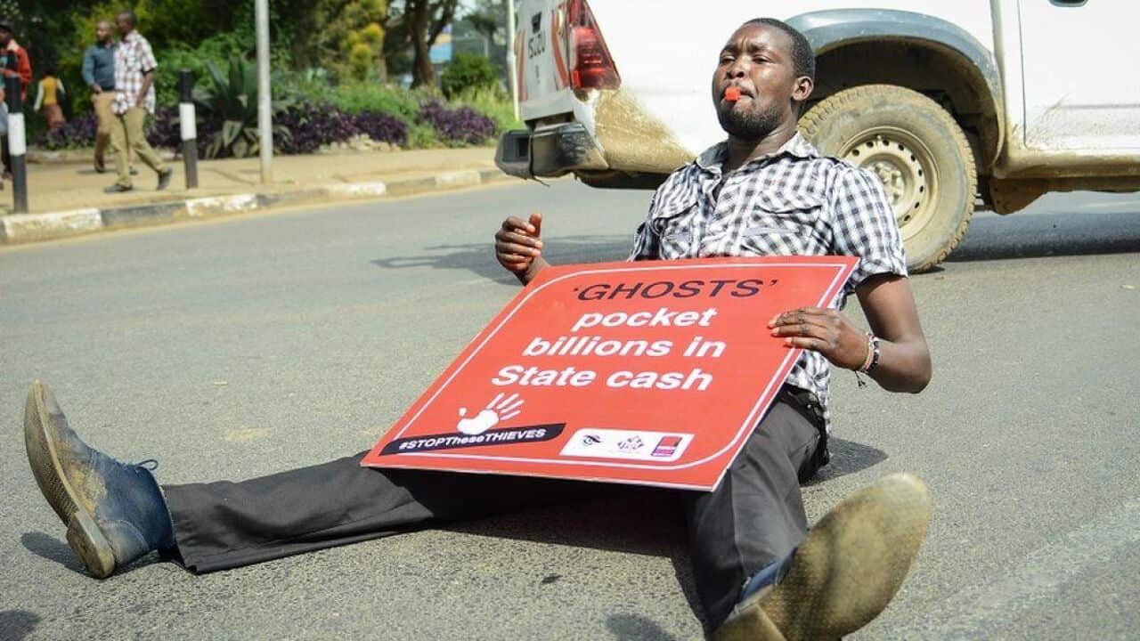 Mkenya na bango lake katika maandamano dhidi ya ongezeko yamadeni