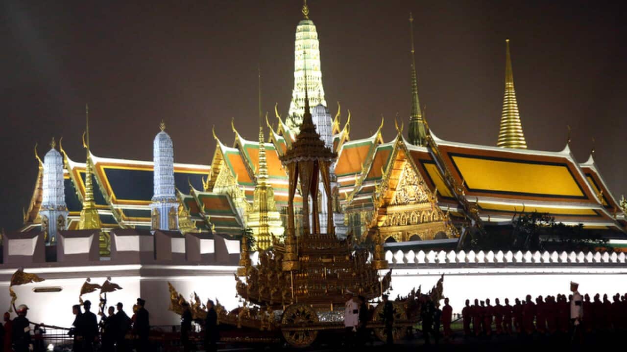 Royal officials pull the royal chariot past Bangkok's Grand Palace (AAP)