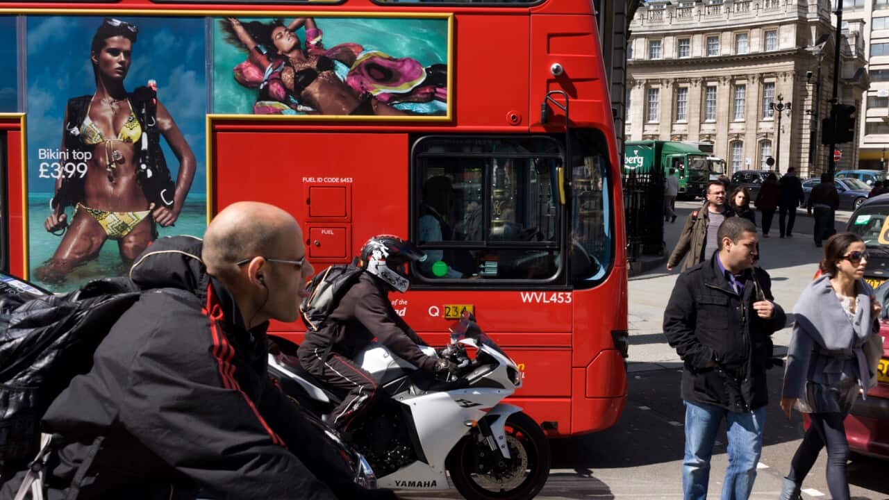 Bikini-wearing model on a bus ad in a busy London street.