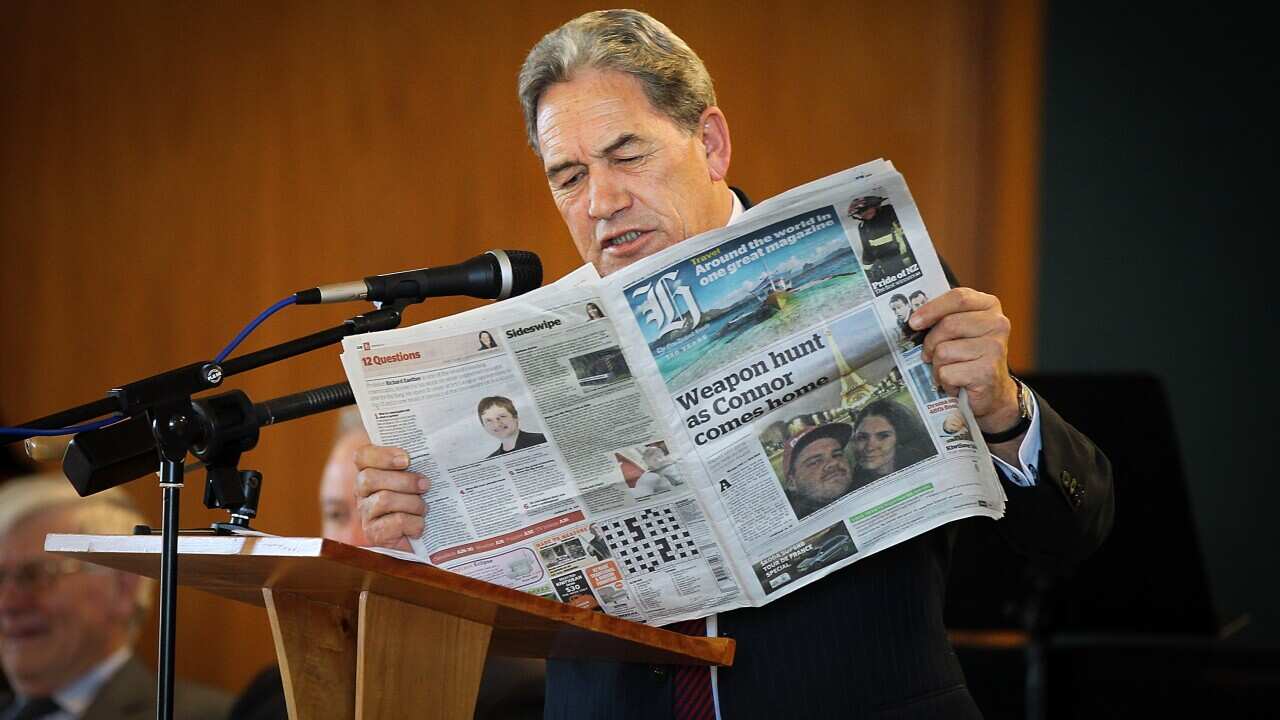 New Zealand politician Winston Peters reads from newspaper during speech