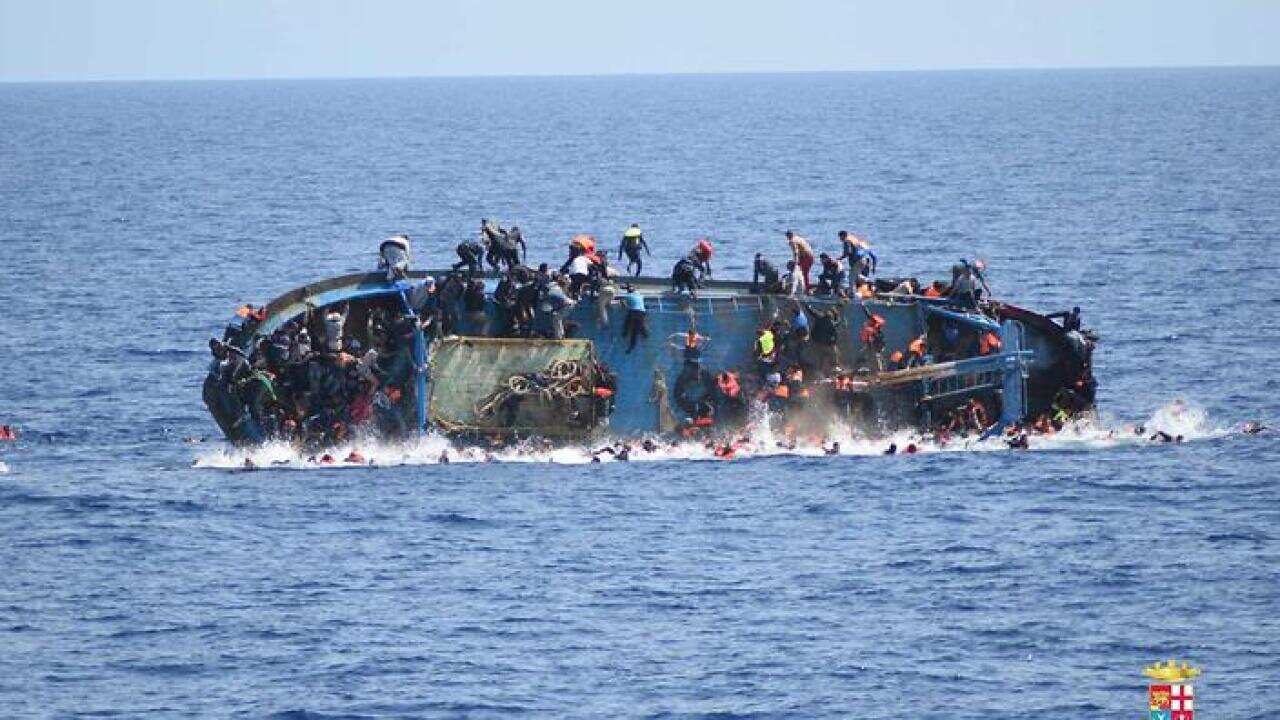 People jumping out of a boat right before it overturns in Canal of Sicily off the Libyan coast, 25 May 2016.